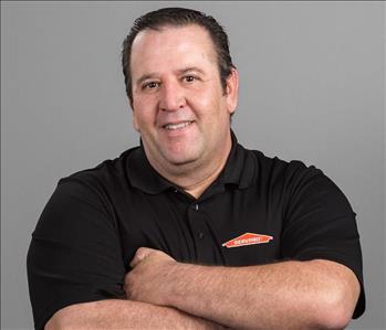 Male Lead Technician with brown hair smiling in front of gray background 